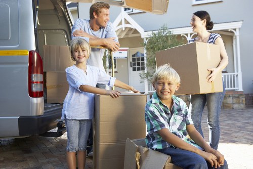 Professional movers carrying items through a Fulham flat staircase